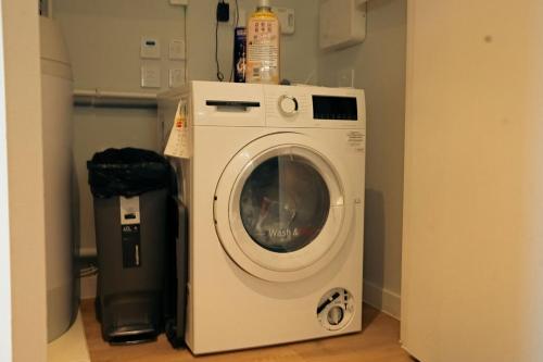 a white washing machine in a room with a trashcan at Luxury sky suites 2 bedroom 2 bathroom city centre apartment in Manchester