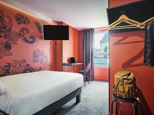 Una habitación de hotel con una cama blanca y una ventana. en Ibis Styles Paris Gare de l'Est Magenta, en París