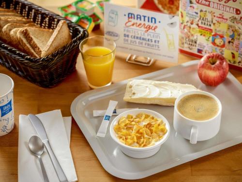 a tray with a plate of breakfast food and a cup of coffee at ibis budget Beauvais Aeroport in Beauvais