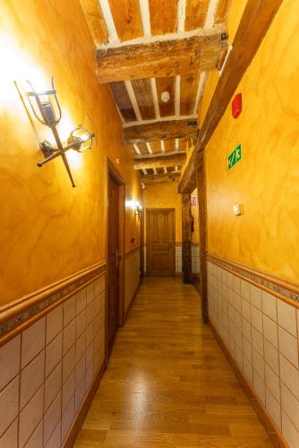 an empty hallway with yellow walls and a ceiling at Hotel Rincón Castellano in Cuéllar