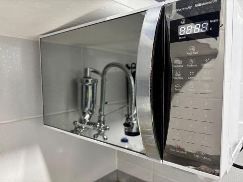 un forno a microonde con un lavandino in una cucina di Edifício Dom Carlos a Rio de Janeiro