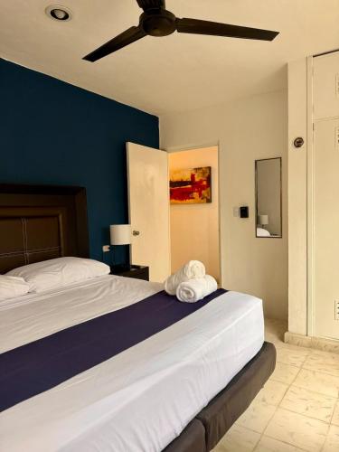 a bedroom with a large bed with a blue wall at Stylish Apt for 5 Pool & Private Garden in Chuburná de Hidalgo