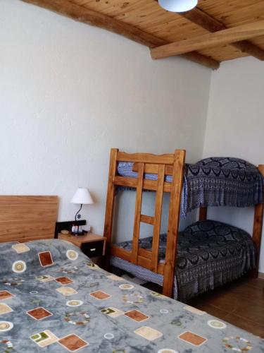 a bedroom with a bed and a chair in a room at Elmosquetal in Villa Yacanto