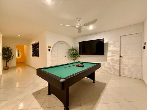 a living room with a pool table and a tv at Stylish Apt for 5 Pool & Private Garden in Chuburná de Hidalgo