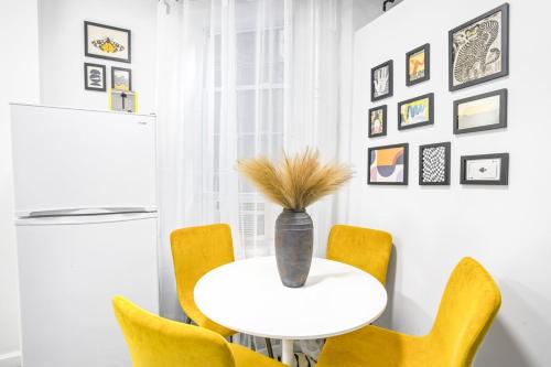 une salle à manger avec une table blanche et des chaises jaunes dans l'établissement Homelike suites in the heart of China Town, à New York