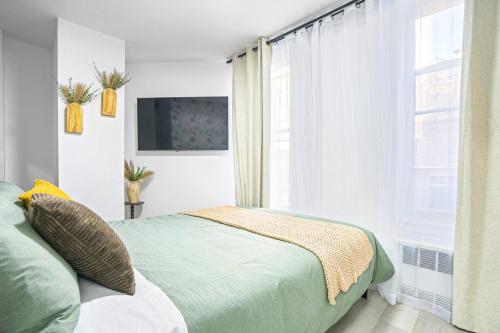 une chambre avec un lit et une grande fenêtre dans l'établissement Homelike suites in the heart of China Town, à New York