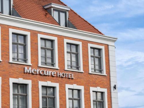 a red brick building with a mercure hotel sign on it at Mercure Saint Omer Centre Gare in Saint-Omer