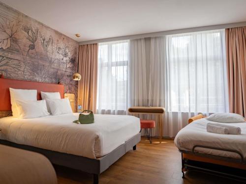 a hotel room with two beds and a window at Mercure Saint Omer Centre Gare in Saint-Omer