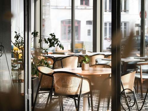 a group of tables and chairs in a restaurant at Mercure Saint Omer Centre Gare in Saint-Omer