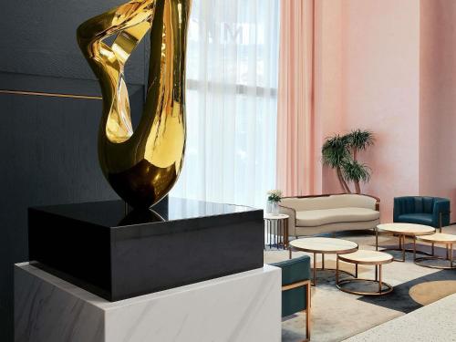 a large yellow vase sitting on a stand in a room at Mercure Xiamen Zhongshan Road Pedestrian Street Seaview in Xiamen