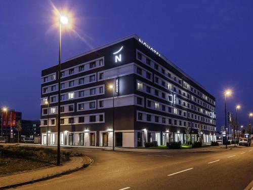 a building on a street at night with street lights at Novotel Duesseldorf Airport in Düsseldorf