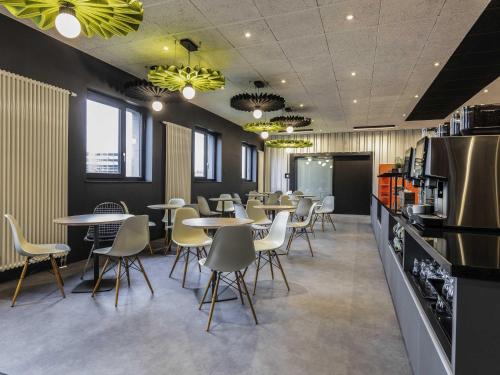 a restaurant with tables and chairs in a cafeteria at ibis Duesseldorf Airport in Düsseldorf