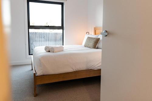 a bedroom with a bed with a window at Villa 3 - Greenstone Villas in St Helens