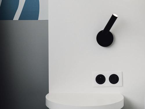 a white wall with a clock on top of a toilet at ibis Styles Nancy Laxou in Nancy