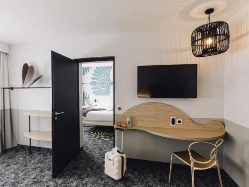 a hotel room with a desk and a bed at ibis Styles Nancy Laxou in Nancy