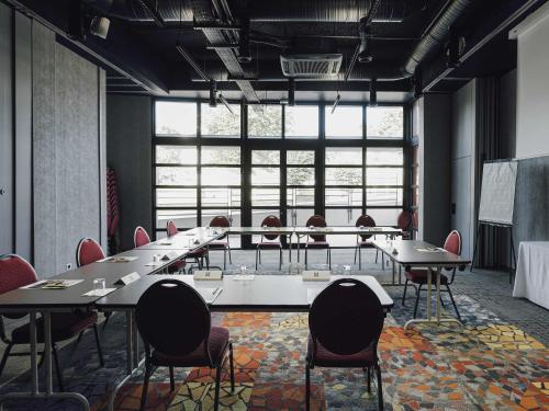 a conference room with tables and chairs and a large window at ibis Styles Nancy Laxou in Nancy