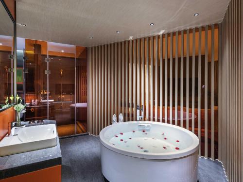 a large bathroom with a tub and a sink at Mercure Nanjing Olympic EXPO in Nanjing