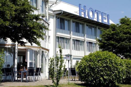 a hotel with chairs and tables in front of it at Hotel Schwanau garni in Schwanau