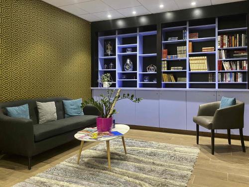 a living room with a couch and a table and chairs at Aparthotel Adagio Bâle Mulhouse Aeroport in Blotzheim