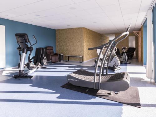 a gym with treadmills and elliptical machines at Aparthotel Adagio Bâle Mulhouse Aeroport in Blotzheim