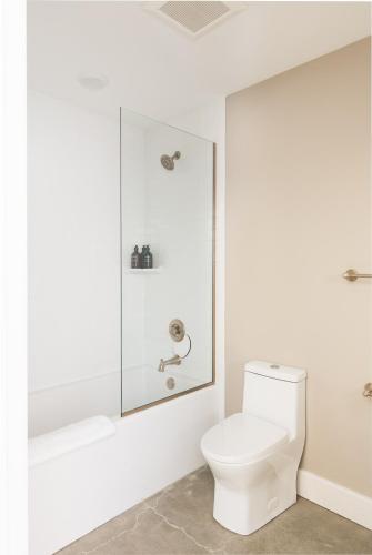 a bathroom with a toilet and a glass shower stall at The Bellwether Hotel in Louisville