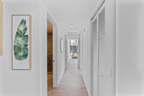 un pasillo de una casa con paredes blancas y suelo de madera en Downtown Miami Luxury Two Bed Two Bath, en Miami