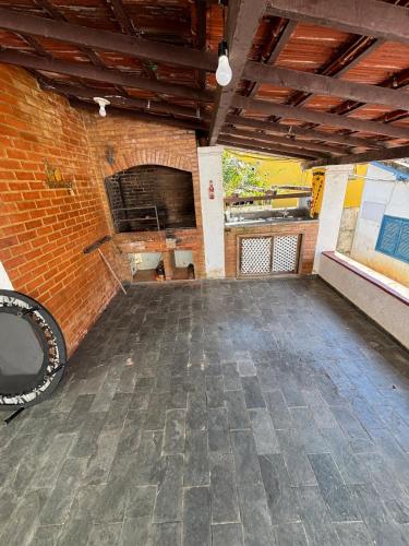 an empty room with a brick wall and a stage at Casa no centro de Miguel Pereira! in Miguel Pereira