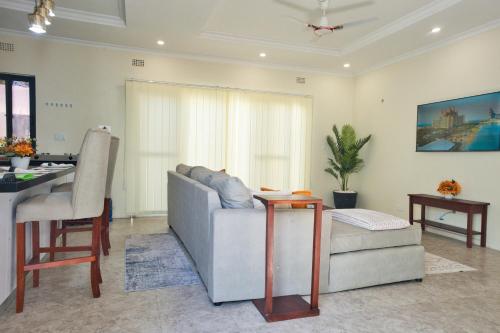 a living room with a couch and a table at The Emerald Apartments Ibex Meanwood in Lusaka