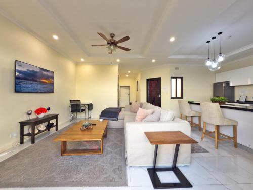 a living room with a white couch and a table at The Emerald Apartments Ibex Meanwood in Lusaka