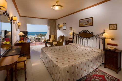 a bedroom with a bed and a balcony with the ocean at Hotel San Agustin Beach Club in San Agustin