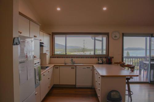a kitchen with white appliances and a large window at Perfect Break whole house in Crescent Head