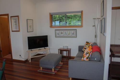 a living room with a couch and a television at Perfect Break whole house in Crescent Head