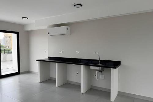 a kitchen with a black counter and a sink at Max Jardim São Paulo in São Paulo