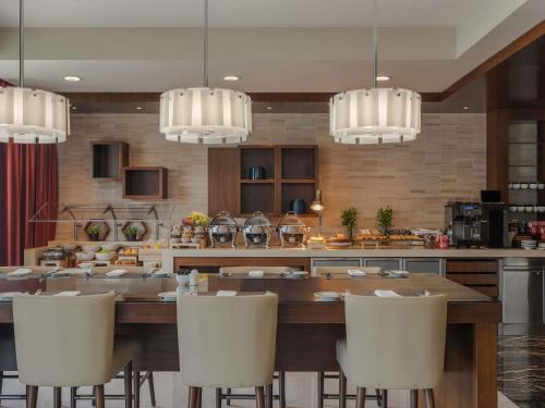 a kitchen with a large wooden table and white chairs at Swissôtel Al Ghurair Dubai - Deira & Creek in Dubai