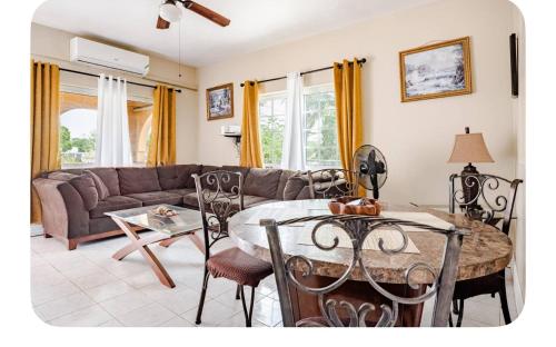 a living room with a table and a couch at Brytan Villa in Treasure Beach