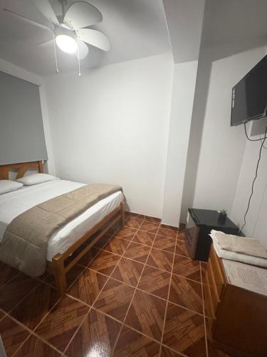 a bedroom with a bed and a flat screen tv at Hospedaje Casa Aluha in Los Órganos