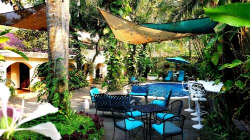 a patio with tables and chairs next to a pool at Hotel Boutique La Casona in Axtla