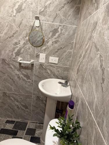 a bathroom with a sink and a toilet and a mirror at Habitación 1 persona cerca de aeropuerto,terminal de buses y estadio in Soledad