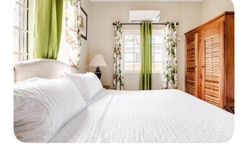 a white bed in a bedroom with a window at Brytan Villa in Treasure Beach