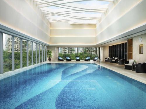 a large swimming pool in a hotel lobby with windows at Fairmont Chengdu in Chengdu