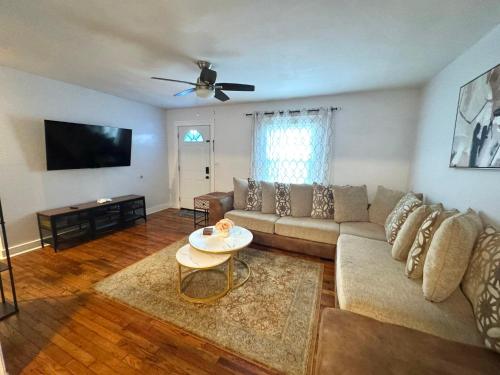 a living room with a couch and a flat screen tv at Charming 3 BDRM in Charlotte - 1 mile to Uptown in Charlotte