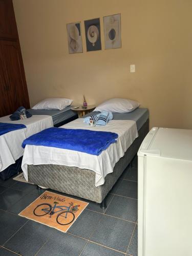 two beds in a room with a sign on the floor at Suíte Pérola in Campo Grande