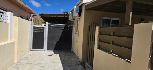 a gate to a house with a fence at Taminaka Apartamento Comfortable III in Paradijs