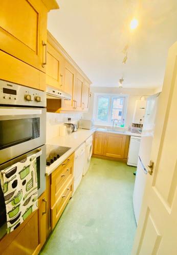 a kitchen with wooden cabinets and white appliances at Great apartment, Great location for 6 guests in London