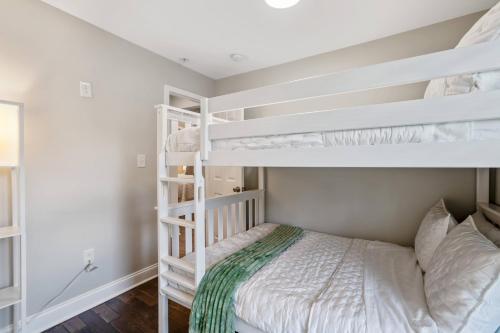 a bedroom with white bunk beds in a room at Walk to the stadium, downtown, West St - close to everything in Annapolis