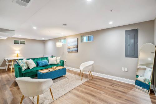 a living room with a green couch and a table at Walk to the stadium, downtown, West St - close to everything in Annapolis