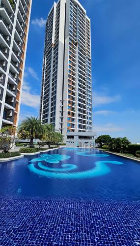 a large swimming pool in front of two tall buildings at Artisan Ratchada Condo Bangkok in Bangkok