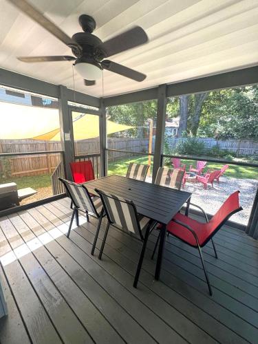 a table and chairs on a porch with a ceiling fan at Charming 3 BDRM in Charlotte - 1 mile to Uptown in Charlotte