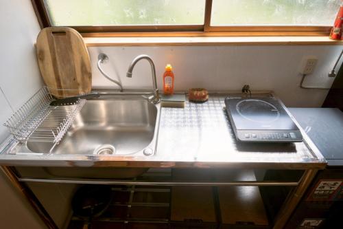 a kitchen with a sink and a counter top at 1日1組限定 森の中の貸切コテージundo in Narusawa