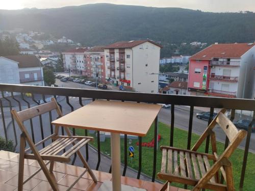 un tavolo e sedie su un balcone con vista sulla città di Seia Flat Mountain Seia View a Seia